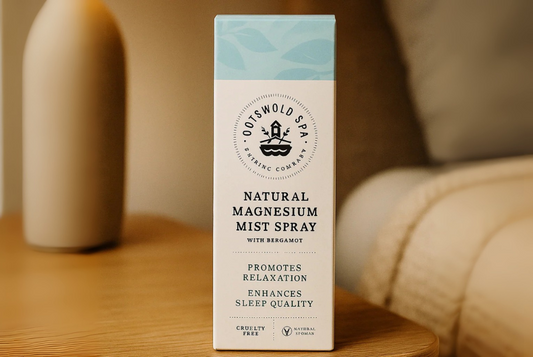 Flesje magnesium spray op een nachtkastje naast een bed met hierachter een nachtlamp.