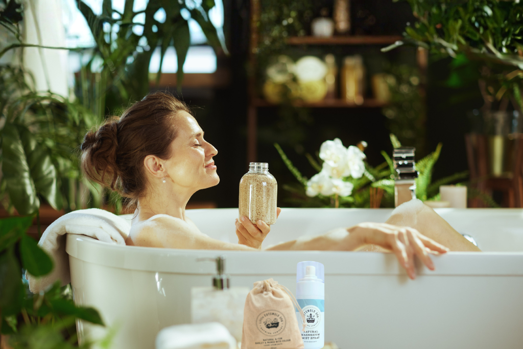 Vrouw ontspant in bad met epsomzout en magnesium spray als onderdeel van een rustgevend selfcare moment