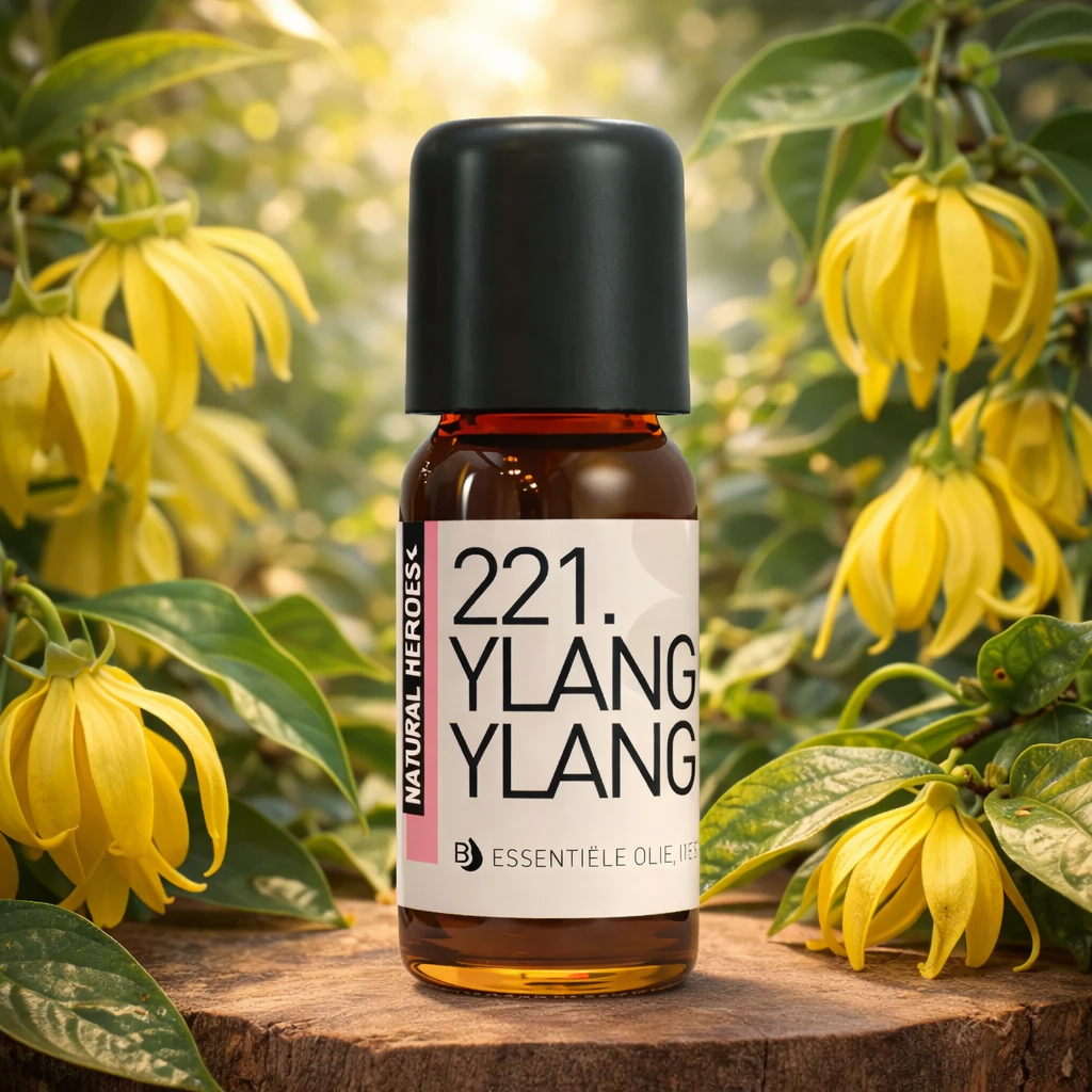 Een klein bruin glazen flesje met de tekst Natural Heroes essenstiële olie 221. ylangylang  tussen bloemen van Ylang Ylang en groen.